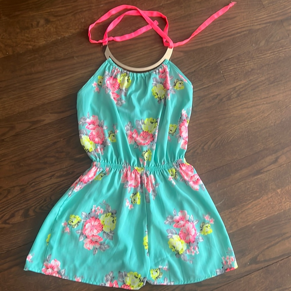 Floral romper with gold accent neck tie.